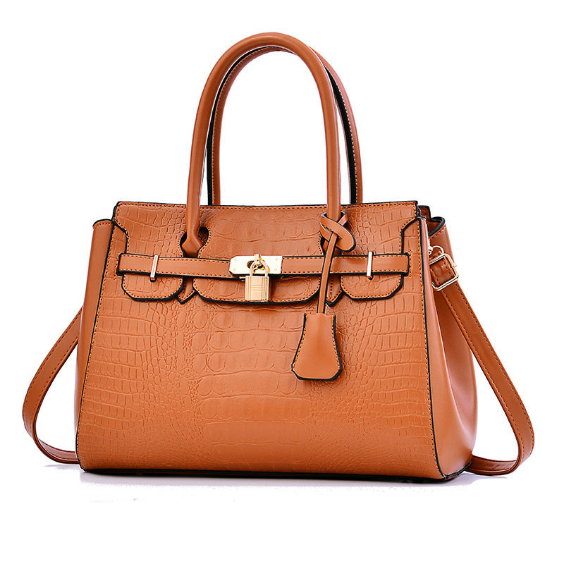 Brown leather handbag with a gold lock on a white background