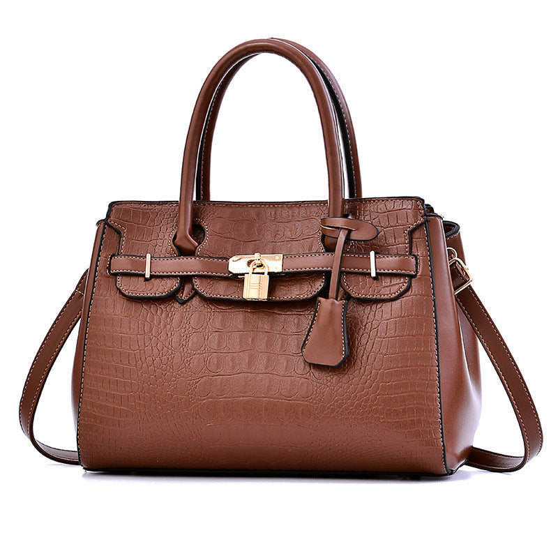 Brown leather handbag with a gold lock on a white background