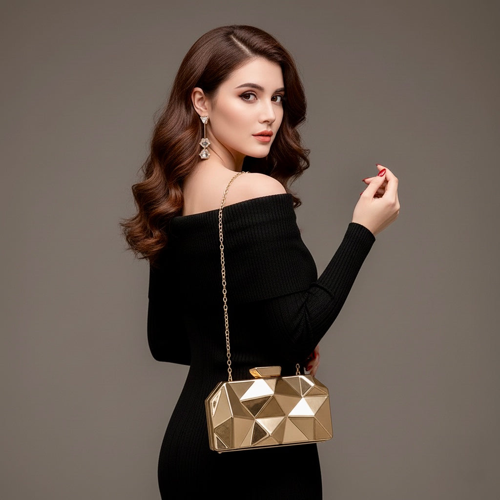 Model wearing the Baazuu Prism Aura acrylic clutch in gold. The modern box clutch features a 3D faceted design, perfect as a statement evening bag.