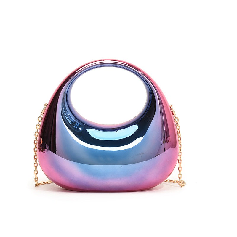 Front view of the Golden Eclipse handbag in a metallic multicolor finish. The bag has a unique crescent shape with a large circular handle cutout and a delicate gold chain strap. brand baazuu