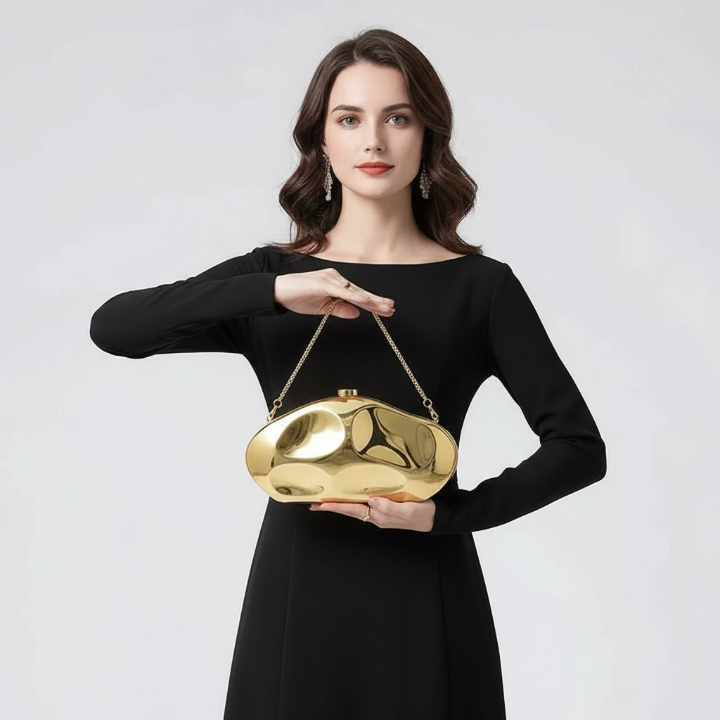 Woman holding a gold handbag against a plain background
